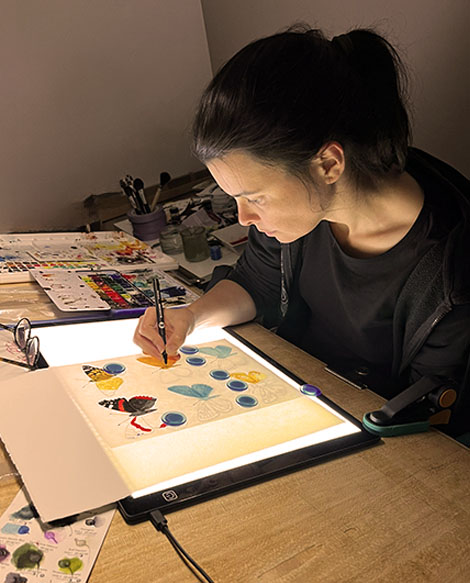 Julie Vigneron, illustratrice, en train d’encrer à l’aquarelle des papillons pour le livret-jeu sur la forêt de Marchiennes
